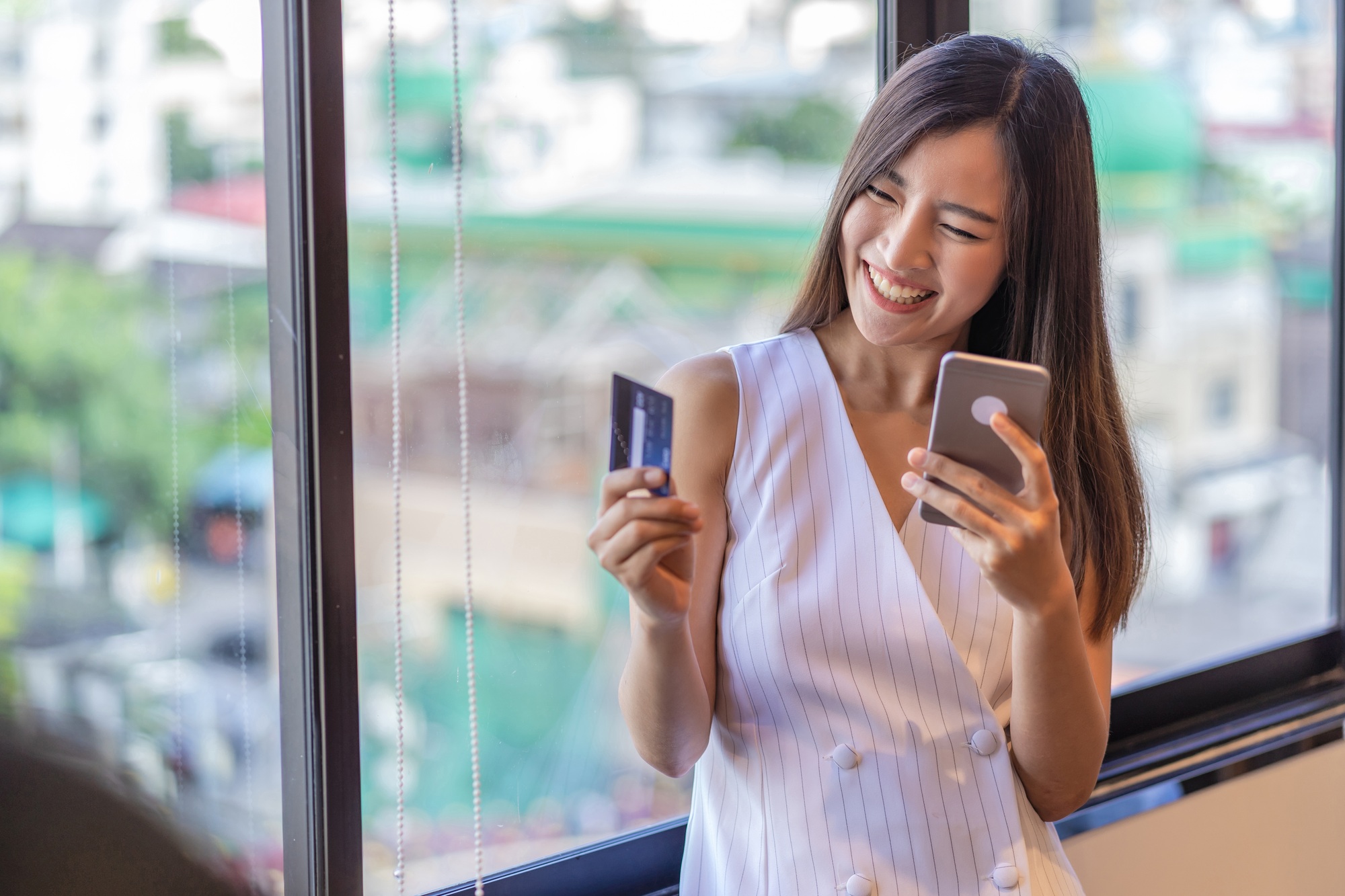 Asian businesswoman in casual suit doing online shopping by using credit card